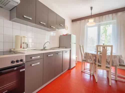 Il comprend une cuisine équipée d'un réfrigérateur et d'une table avec une chaise. dans l'établissement Holiday Home Andrijana by Interhome, à Novi Vinodolski