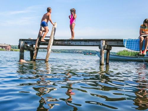 a group of people on a dock on the water at Holiday Home Naurulokki 4 by Interhome in Strandby