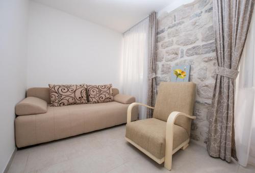a living room with a couch and a chair at Apartment Kula Đurišić in Perast