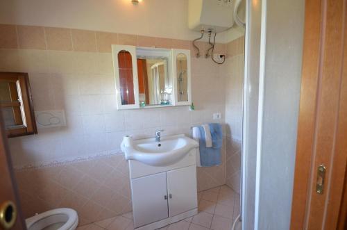 a bathroom with a sink and a toilet and a mirror at Casa Mela in Vinci