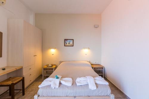 um quarto com uma cama com toalhas em Voukelari Rooms em Plakiás