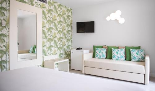 a white room with a white bed and a mirror at Hotel Cristal Praia Resort & SPA in Praia da Vieira