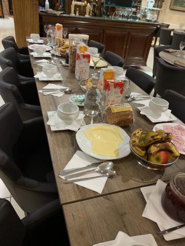 a long wooden table with plates of food on it at Résidence la floraison in Brussels
