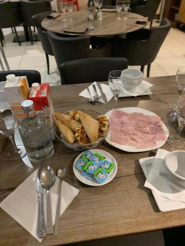 a wooden table with plates of food on it at Résidence la floraison in Brussels