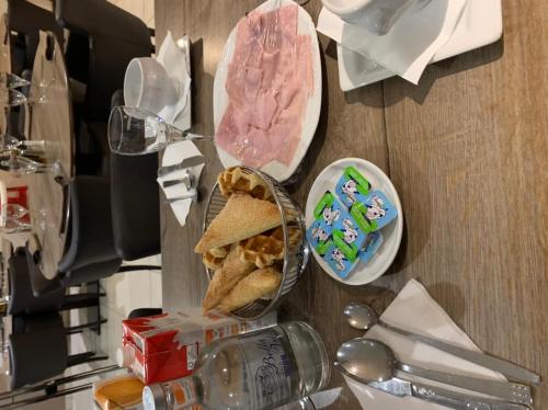 a table with a sandwich and a plate of food at Résidence la floraison in Brussels