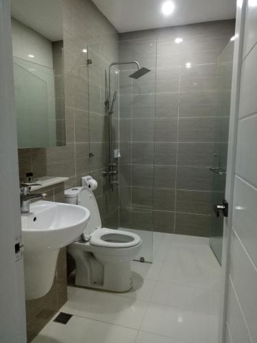 a bathroom with a toilet and a sink and a shower at Chequers Suites Subic Bay in Olongapo