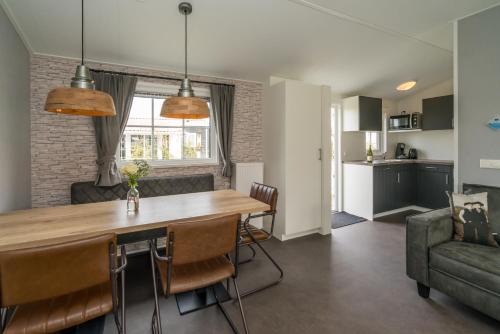 een keuken en een woonkamer met een tafel en stoelen bij Camping De Strandloper in Scharendijke