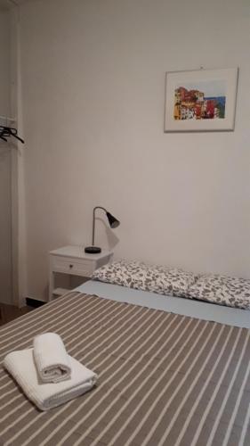 a bedroom with a bed with a blanket and a lamp at La Ginestra in Corniglia