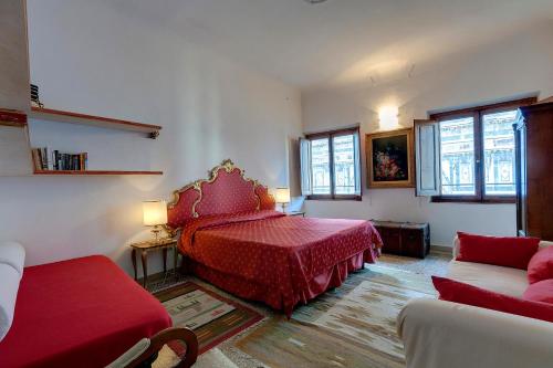una camera con letto rosso e divano di Eden a Firenze