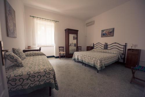 una camera da letto con due letti e una finestra di Masseria Perronello Country House a Castellaneta Marina