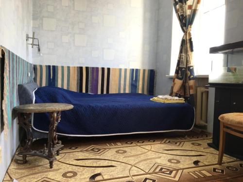 モスクワにあるКвартира на Курскойのベッドルーム(青いベッド1台、テーブル付)