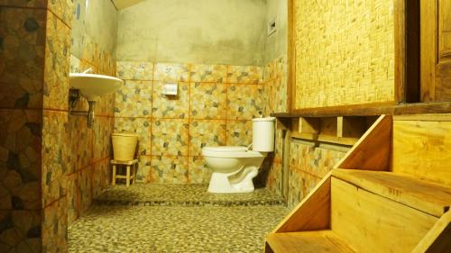 a bathroom with a toilet and a sink at Vanilla Garden in Tetebatu