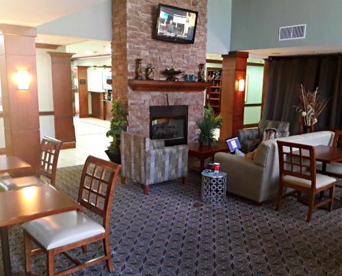 a lobby with a living room with a fireplace at WeStay Suites - Covington/Mandeville in Covington