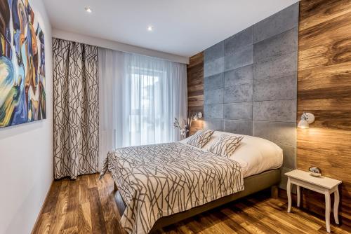 - une chambre avec un lit et une grande fenêtre dans l'établissement Apartament Merkury z parkingiem, à Toruń