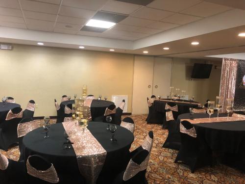 a conference room with tables and chairs with wine glasses at WeStay Suites - Covington/Mandeville in Covington