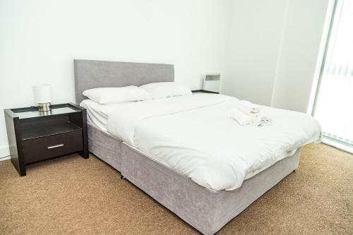 a bedroom with a large bed and a night stand at Serviced Apartment In Liverpool City Centre - Free Parking - Balcony - by Happy Days in Liverpool