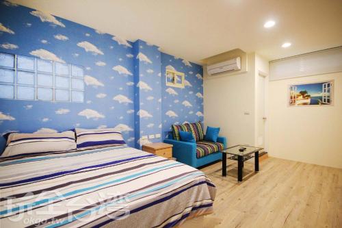 una camera da letto con pareti blu e un letto e una sedia di Aqua Night Market Homestay a Luodong