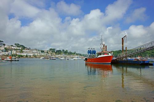 a red boat is docked at a dock in the water at Havener's in Fowey