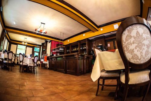 a dining room with tables and chairs in a restaurant at Hotel Trei Brazi in Băile Olăneşti