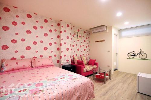 una camera con letto rosa e parete fiorita di Aqua Night Market Homestay a Luodong