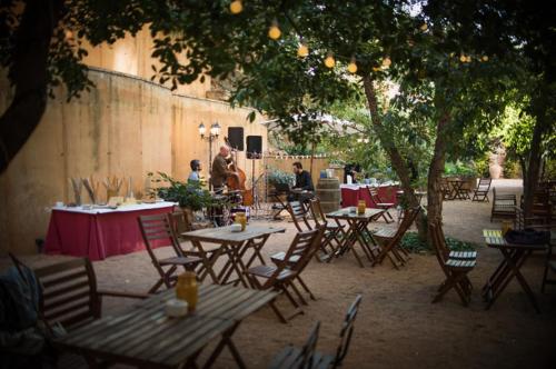 a group of tables and chairs under a tree at Hotel-Hostal Sport in Falset