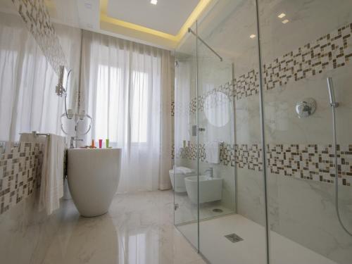 a white bathroom with a glass shower and a sink at Palazzo Firenze in Naples