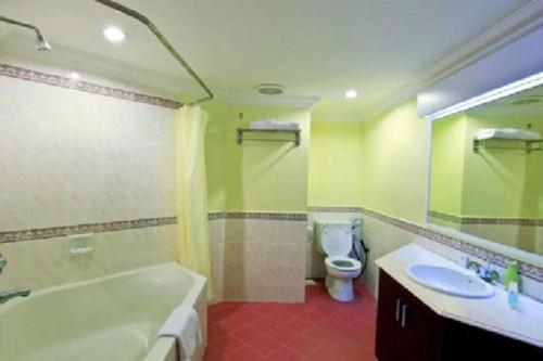 a bathroom with a tub and a toilet and a sink at D'Vista Apartments in Lotus Desaru Beach Resort in Desaru