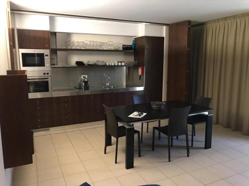 a dining room with a table and chairs and a kitchen at Salgados Beach in Albufeira
