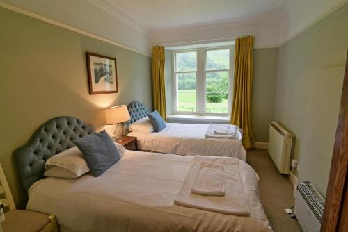 a hotel room with two beds and a window at Gardeners Cottage in Chesthill