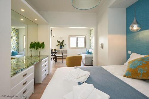 a bedroom with a bed and a dining room at Rainha II Beach Apartment in Cascais