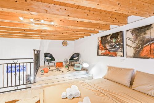 - une chambre avec un lit et deux chaises dans l'établissement Palazzo dei Normanni Stylish Apartment, à Palerme