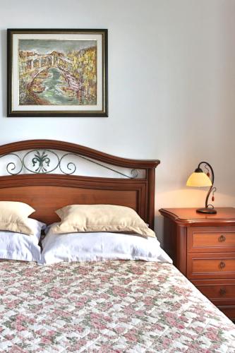 a bedroom with a bed and a dresser and a picture at Royal Holiday Apartments Sveti Stefan in Sveti Stefan
