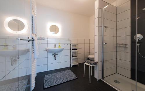 La salle de bains blanche est pourvue d'un lavabo et d'une douche. dans l'établissement Apart Hotel - Dillinger Schwabennest, à Dillingen an der Donau