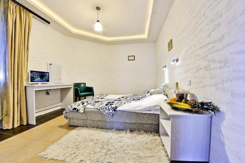 a bedroom with a bed and a table with fruits on it at Vila Etna in Ugrinovci