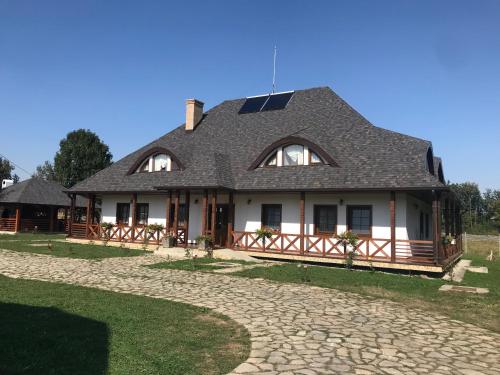 a large white house with a gambrel roof at Casa Strabunicului in Pîrteştii de Sus