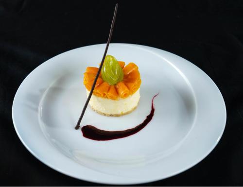 a white plate with a dessert with oranges on it at Olinia Airport Hotel in Katunayake