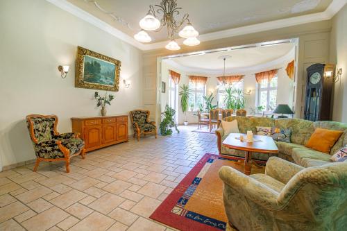 a living room with a couch and a table and chairs at Villa Parkhaus in Wernigerode