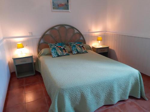 - une chambre avec un lit et 2 lampes sur 2 tables dans l'établissement Appartement Côté Sud vert, à Sarlat-la-Canéda