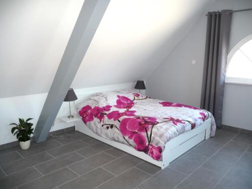 een slaapkamer met een bed met roze bloemen erop bij Charmant sudio aux portes de Colmar in Durrenentzen