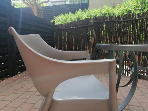 a white chair sitting next to a table at The Bridgeview in Johannesburg