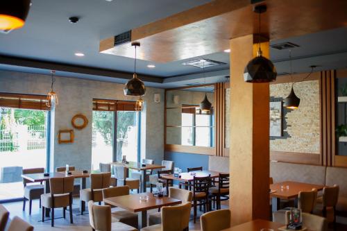 a dining room with tables and chairs and windows at VonAmor Rooms in Novi Sad