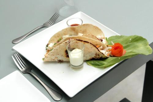 um prato branco com um sanduíche e um copo de leite em Somerset Mirissa Beach em Mirissa