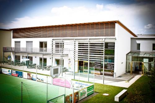 a building with a tennis court in front of it at Jugendherberge Bad Tölz in Bad Tölz