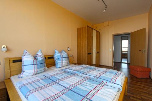 - une chambre dotée d'un grand lit avec des oreillers bleus et blancs dans l'établissement Ferienwohnungen mit Weitblick, à Thale