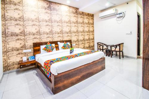 1 dormitorio con 1 cama y 1 mesa en una habitación en FabHotel Elysian Grand Lucknow Airport, en Lucknow