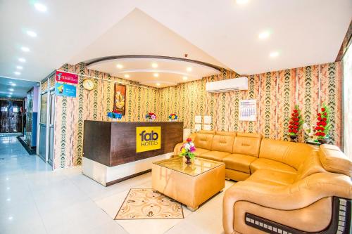 een woonkamer met een bank en een tv bij FabHotel Elysian Grand Lucknow Airport in Lucknow