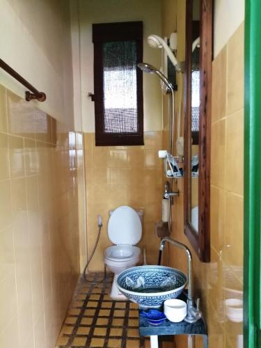 a bathroom with a toilet and a sink with a shower at Baan Tepa Boutique House in Bangkok
