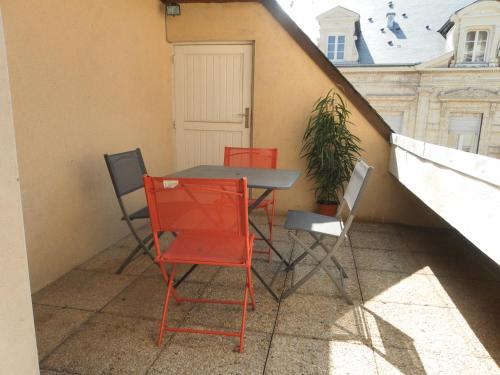a table and chairs on a balcony with a plant at CHARMANT APPARTEMENT CENTRE VILLE LE RONSARD in Nogent-le-Rotrou