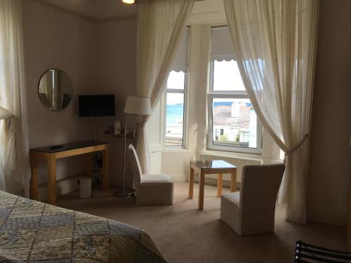 1 dormitorio con cama, escritorio y ventana en Windsor Lodge B&B en Dun Laoghaire