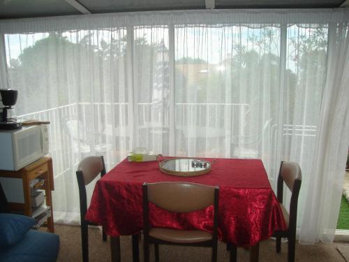 une table à manger avec un tissu de table rouge et une fenêtre dans l'établissement la meridienne, à Sète
